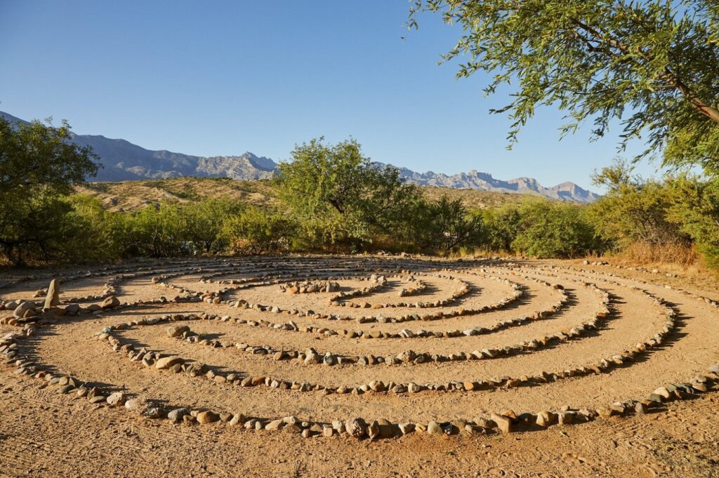 A rugged rock labyrinth weaving through sun-baked earth at Miraval Resort’s edge