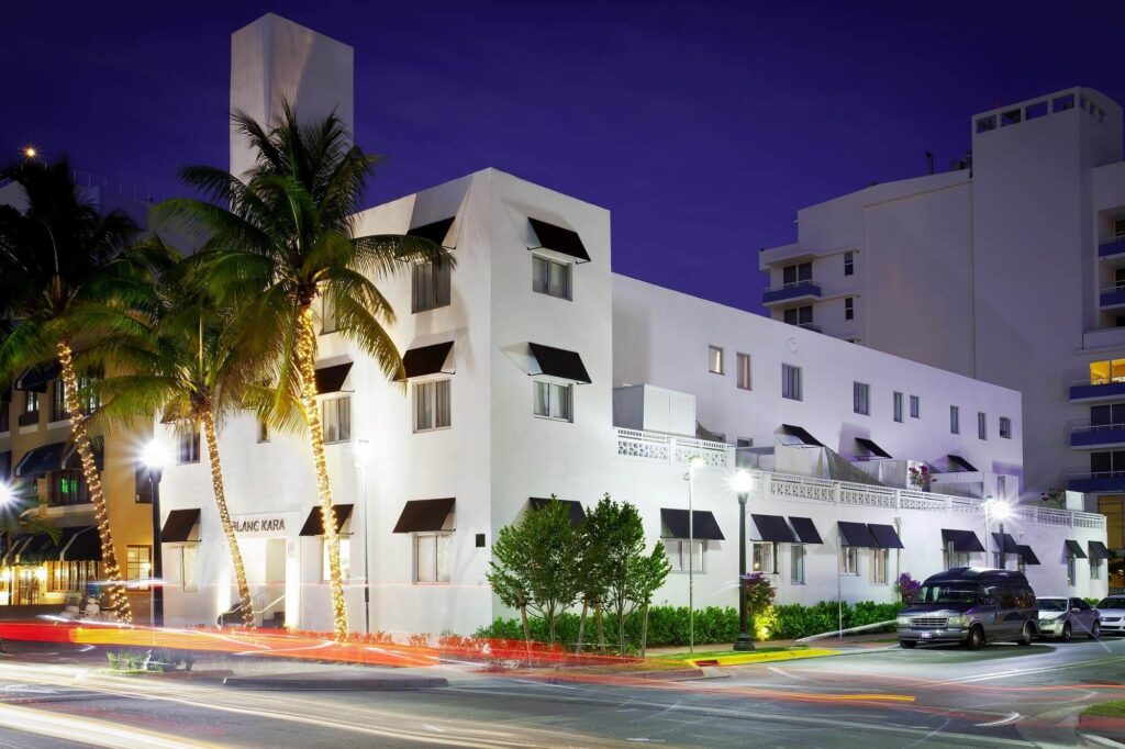 Blanc Kara’s crisp white Art Deco façade glowing at dusk