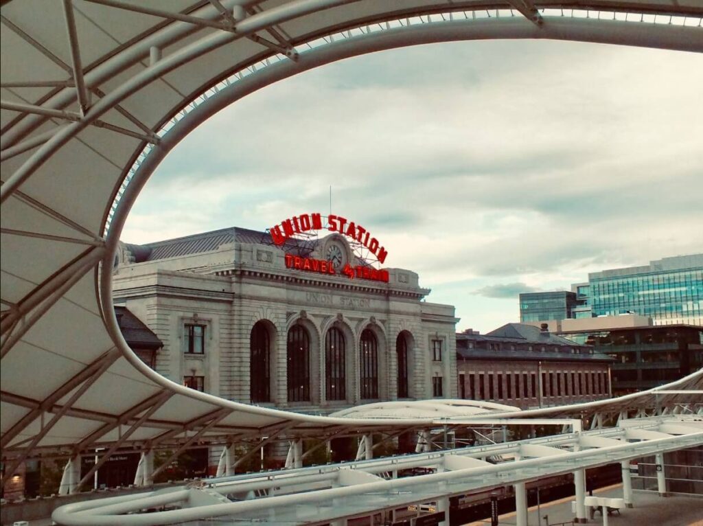 Curved steel canopy framing the historic Union Station at Denver’s bustling transit hub