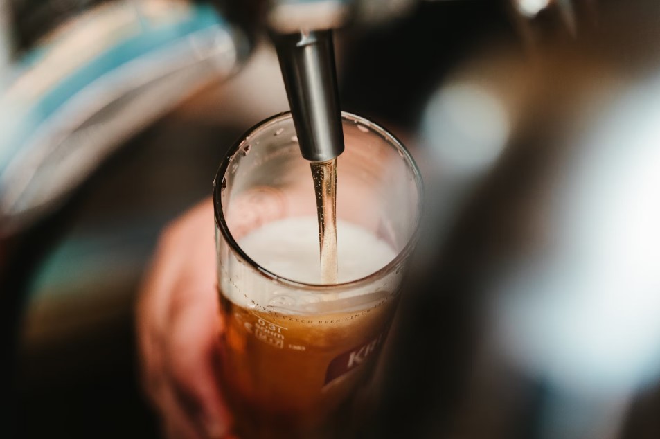 Foam-topped amber ale filling a chilled glass at a Denver brewery