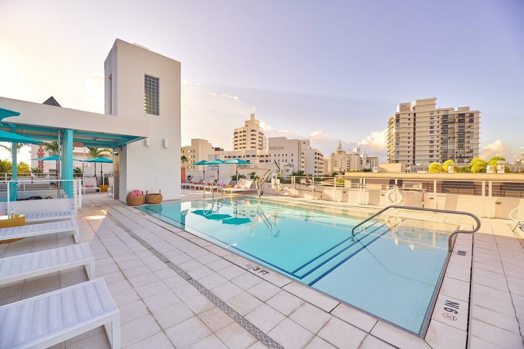 Hotel Greystone’s rooftop pool overlooking pastel Art Deco skyline