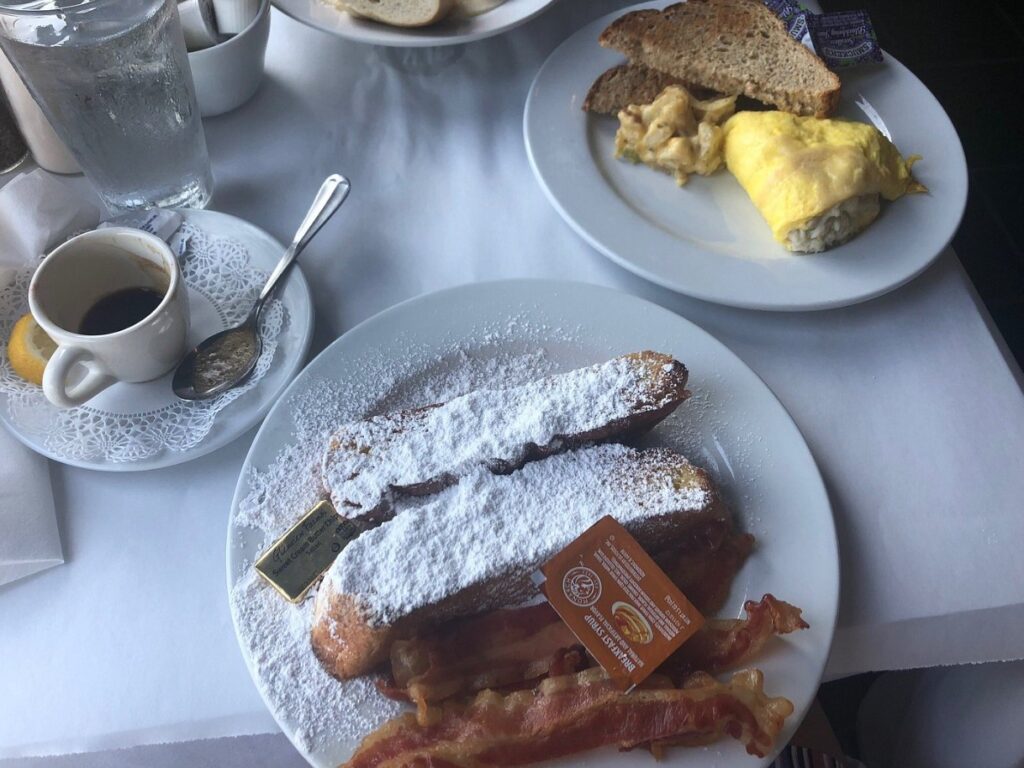 Huey’s on the River’s sugar-dusted French toast paired with bacon and dark espresso