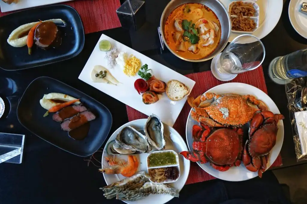 Jumbo oysters, crab, and tom yum soup plated for a coastal seafood feast