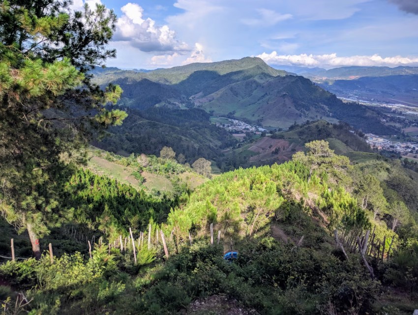 Mist‑tipped green mountains cascading toward a valley in the Dominican Republic.