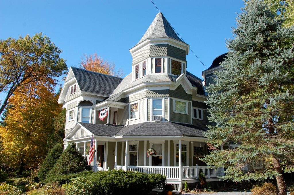 Sinclair Inn’s Victorian turret rising above a wraparound porch framed by golden foliage
