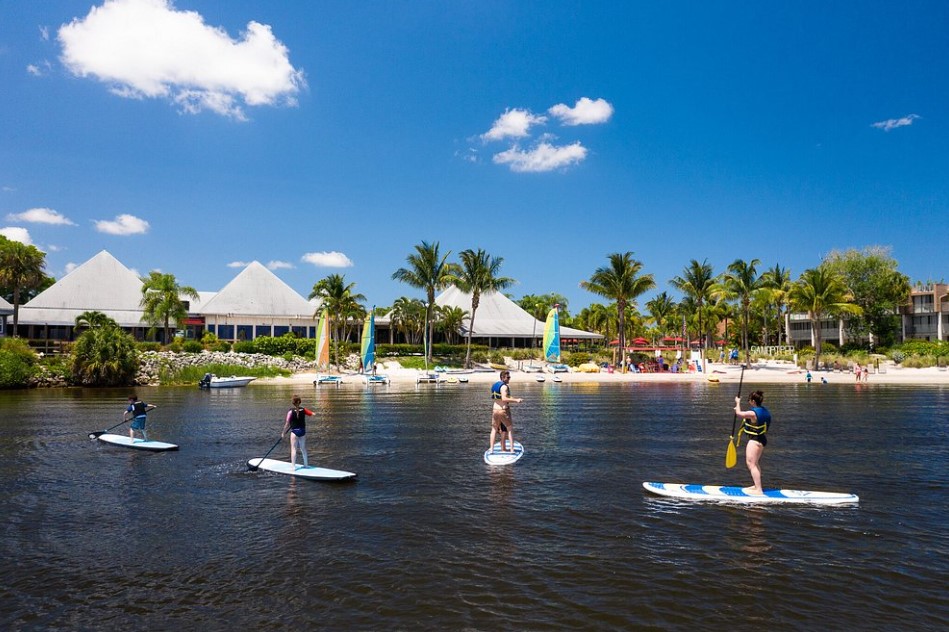 Stand-up paddlers gliding past beachfront villas at Sandpiper Bay Resort