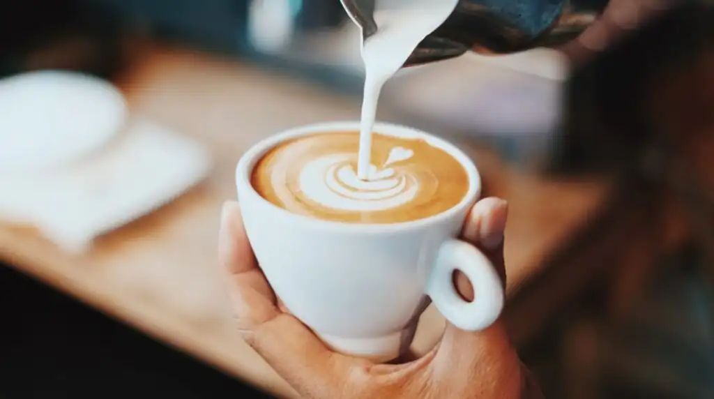 Steaming latte art being poured into a cup at Tybean Coffee and Art Bar