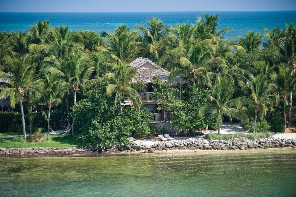 Thatched-roof hideaways nestled among palm groves on Little Palm Island Resort