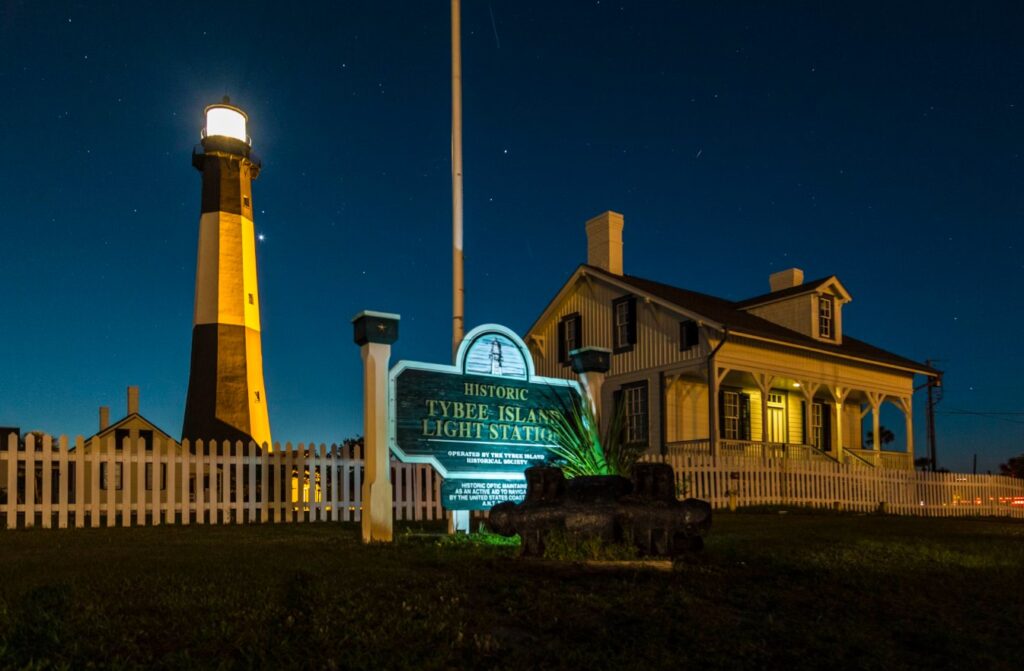 Tybee Island’s black-and-white lighthouse beaming against a star-filled coastal sky