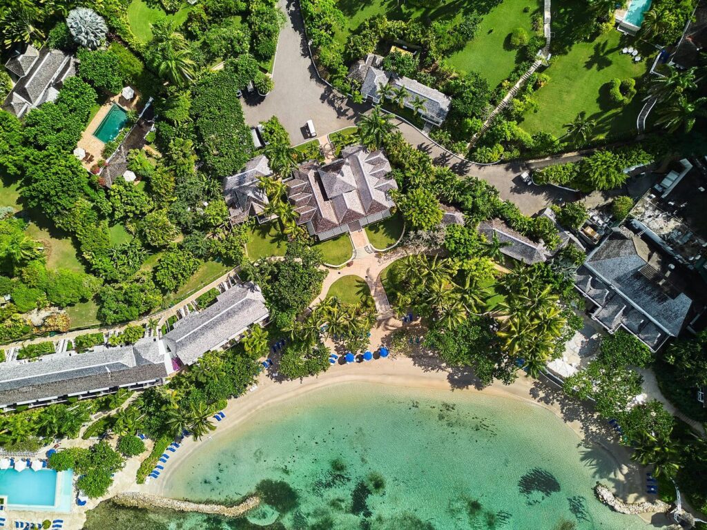 Elegant villas peek through lush gardens above the bay at Round Hill Hotel and Villas, Jamaica