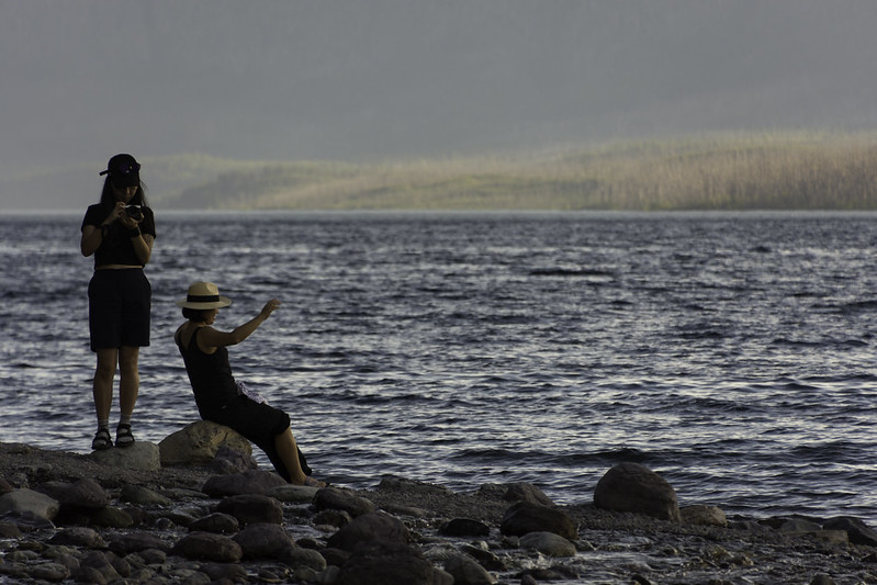 Evening light casts calm shadows over Lake McDonald's pebbled shore
