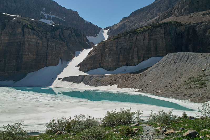 Glacial melt forms a turquoise pool beneath icy cliffs at Upper Grinnell Lake