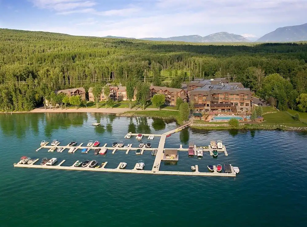 Boat-lined marina and lakeshore resort buildings at The Lodge at Whitefish Lake