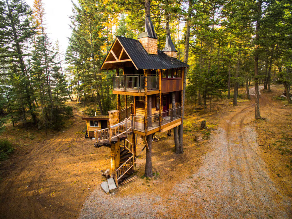 Fairytale–style treehouse perched among pines on the edge of the forest at Montana Tree House