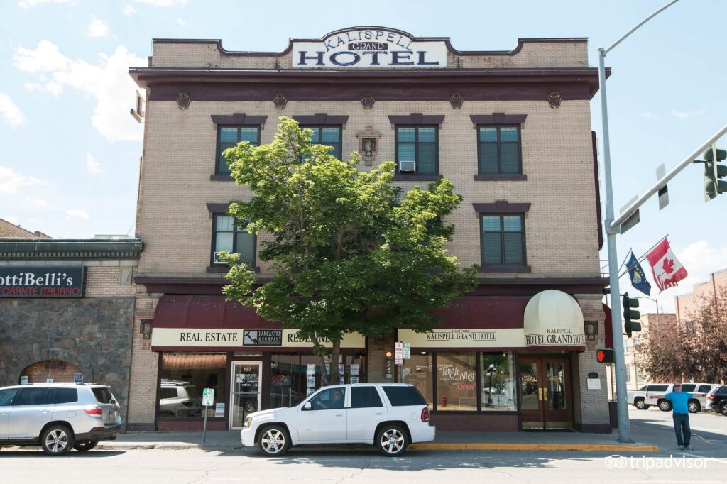 Historic brick exterior of the Kalispell Grand Hotel rising above downtown sidewalks at Kalispell Grand Hotel