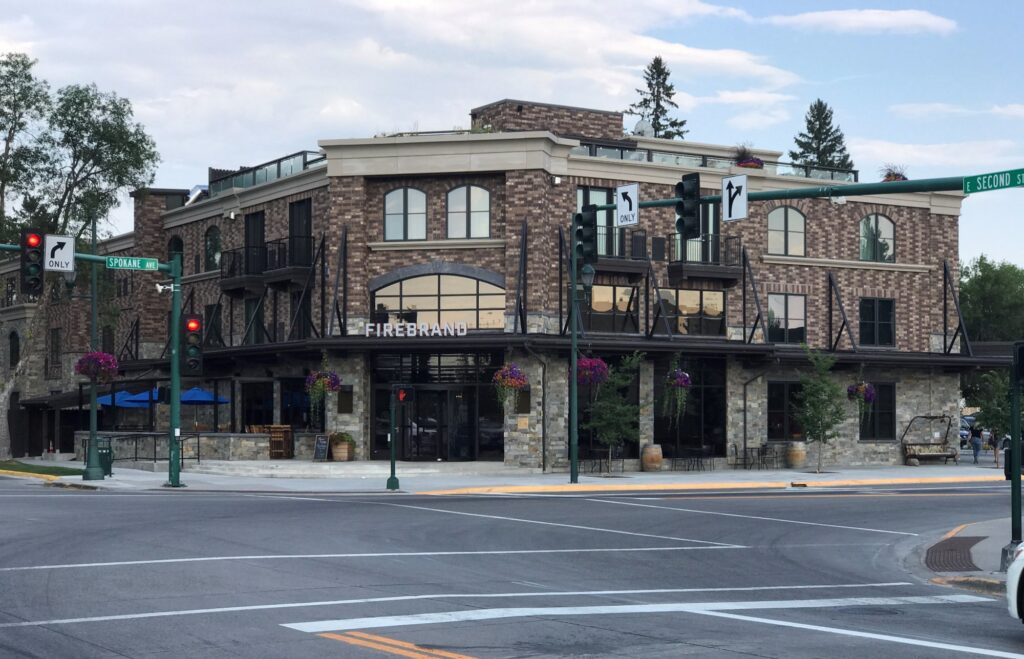 Rustic stone-and-wood exterior of The Firebrand Hotel at the corner of Main Street